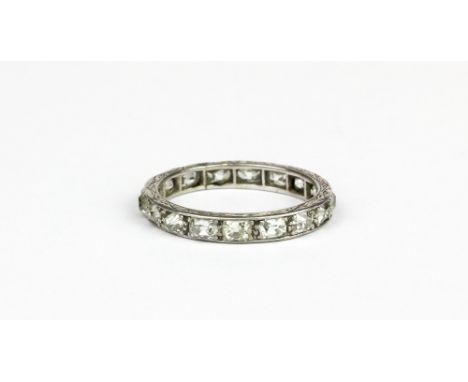 A white metal (tested platinum) eternity ring set with old oval cut diamonds, (M.5).