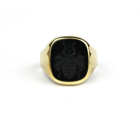 A yellow metal (tested minimum 9ct gold) carved onyx gentleman's signet ring, (W.5).