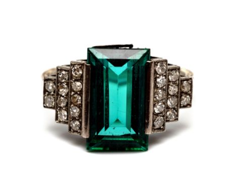 14 kt. Witgouden ring, Art Deco.  Centraal bezet met een rechthoekige groene toermalijn. De schouders getrapt en bezet met ac