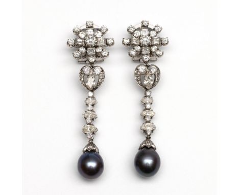 14 kt. Witgouden oorclips. Bestaande uit een ster bezet met briljant en carré geslepen diamant waaronder twee voluten en een 