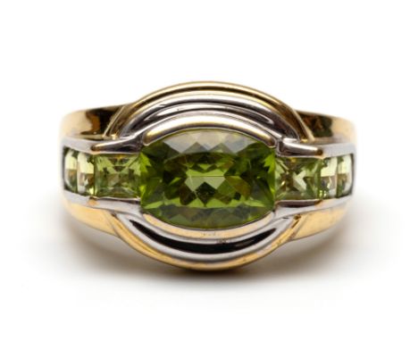 18 kt. Gouden ring, bezet met tonvormige en carré geslepen peridoot, in witgoud gezet (krasjes) bruto 6,4 gr., ringmt. 18 [1]