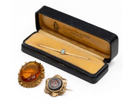 Twee 14 kt. gouden broches, 19e eeuw. Beide met een rijkgedecoreerde rand. Eén bezet mt oranje glas, de ander met bloemen uit