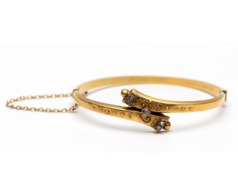 Gouden stijve armband, 19e eeuw. De voorzijde in crossover model, de uiteindes eindigend in een bol. Gedecoreerd met filigrai
