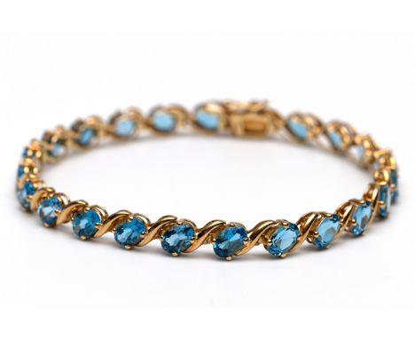 H. Stern, 18 kt. gouden tennis armband, bezet met ovale gefacetteerde topazen (6 x 4 mm), in de kleur Swiss blue, waartussen 