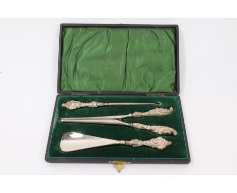 Three piece set of Edwardian dressing implements - comprising glove stretchers, button hook and shoehorn with rococo-style si