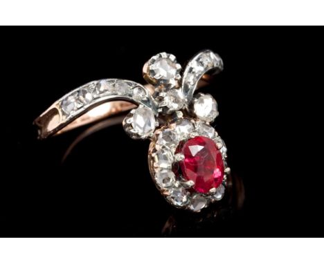 Unusual ruby and diamond cluster ring with an oval cluster centred with a mixed cut ruby weighing approximately 0.72 carats, 