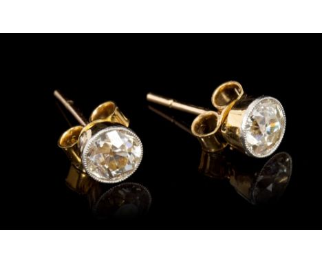 Pair diamond single stone earrings, each with an old cut diamond in millegrain platinum setting, on yellow gold mounts with p