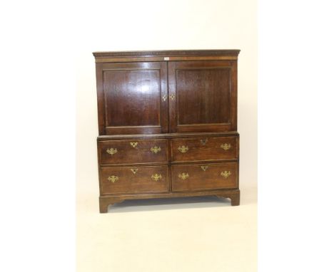 George III oak press cupboard with dentil cornice and interior of slides enclosed by pair of cupboard doors, four short drawe