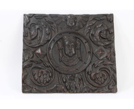 Antique, possibly 17th century carved oak panel centred by mask roundel within cherub and scrolling mask and acanthus ornamen