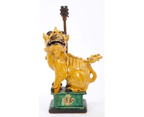 Chinese Dog of Fo with yellow glaze and green glazed pedestal fitted as a table lamp, on ebonised wooden base, 38.5cm high in