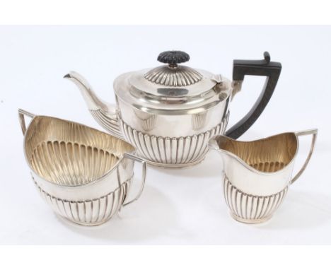 Edwardian silver teapot of half-fluted form, with angular ebony handle, fluted spout and hinged domed and fluted cover with c