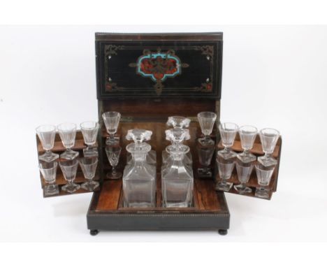 19th century French ebonised and metal inlaid decanter box, the hinged folding cover enclosing interior of four glass decante