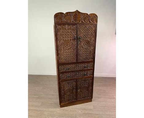 EAST AFRICAN CARVED CUPBOARD,the upper twin doors enclosing single shelf above two short drawers above two further doors, 164