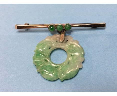 A 9ct brooch mounted with carved jade pendant