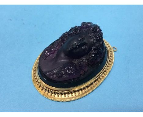 A cameo relief portrait of a female, in yellow metal mount