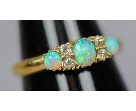 A Victorian 18ct gold opal and diamond ring, set with three graduated opals and four diamonds, ring size L Good condition