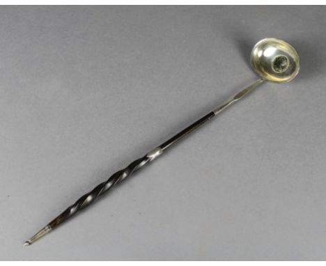 An 18th Century white metal punch ladle with twisted whalebone handle, inset to oval bowl with Queen Anne 1711 shilling inset