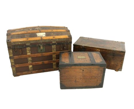 A domed top trunk containing military equipment, including tin helmet, spurs, leather belts, cloth badges, water bottle, arab