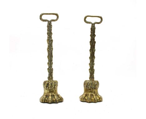 A pair of 19th century brass lion's paw doorstops, each with feathered stem and ring handle, both with iron weights. 39cm hig