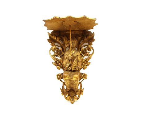 A carved giltwood wall bracket, modelled as a Chinese woman holding a parasol, forming to bracket, 31cm wide, 25cm deep, 49.5