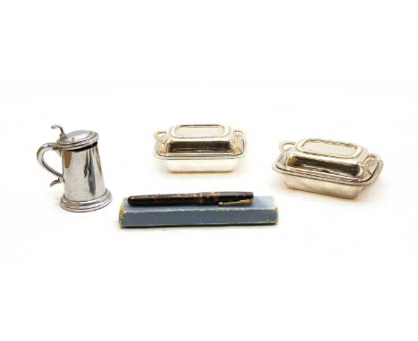 A Dunhill table lighter in the form of a tankard, 9cm high, a pair of Dunhill miniature entree dishes, 12cm wide, and a Water