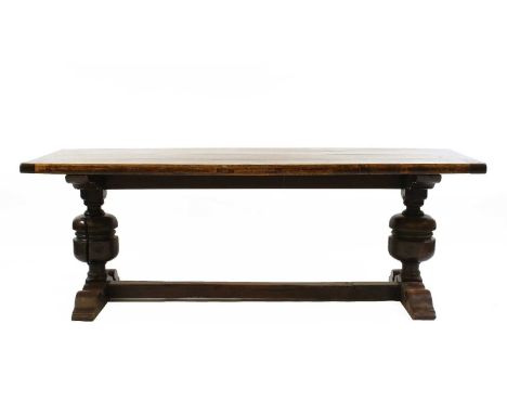 An oak refectory table, the rectangular plank top raised on turned supports united by stretchers, 213cm wide, 73cm deep, 75cm