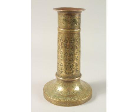A FINE 19TH CENTURY PERSIAN BRASS CANDLESTICK WITH SILVER INLAYS, the body engraved with seated figures, 29cm high.