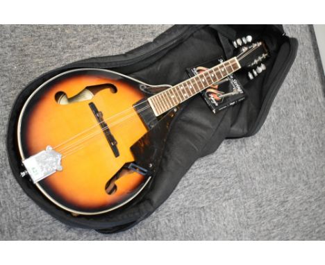 A Fender FM-100 electric mandolin, in padded gig bag, with spare strings, scratch plate loose