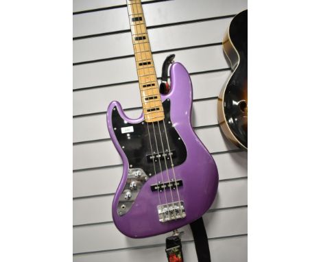 A Fender Squier Jazz Bass, Left Handed in Purple, with padded gig bag