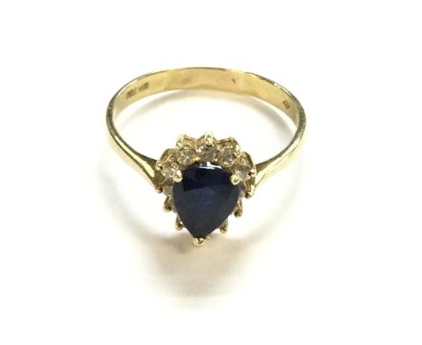 An 18ct gold heart shaped ring with centre gemstone and diamond surround. Size R and 3.67g. Postage B