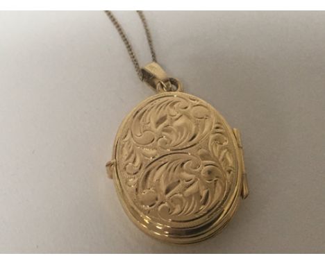 A 9carat gold oval locket and chain. Weight 2.9g