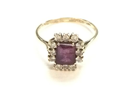 A 9ct gold ring with central ruby and diamond surround. Size T 1/2 and 3.23g. Postage B