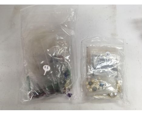 A bag of mixed stones including pearls, jade, garnets and other stones. Shipping category A.