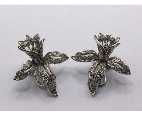 A pair of Vintage white metal and diamond clip on earrings of folate design set with numerous diamonds. Weight 15g