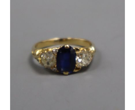 A yellow metal, sapphire and diamond three stone ring (two small diamonds missing and re-sized), size I/J.