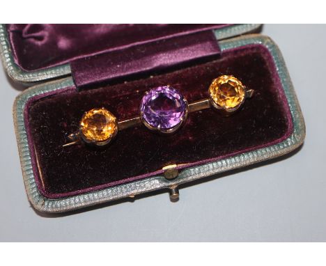 An early 20th century yellow metal, amethyst and citrine three stone bar brooch, 52mm.