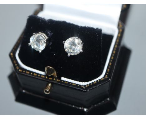 A modern pair of 18ct white gold and solitaire round brilliant cut diamond ear studs, each stone weighing approximately 1.70-