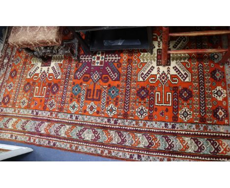 A Kazak style brick red ground carpet 250 x 170cm