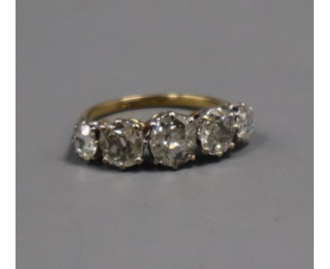 An early 20t century 18ct and plat, graduated five stone old mine cut diamond half hoop ring, the central stone with an appro