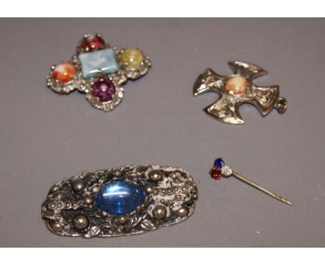 A silver brooch along with two others and a stick pin