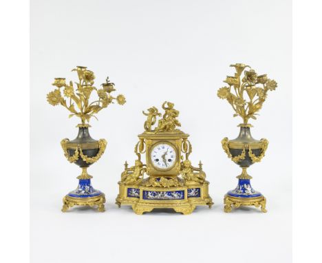 A French three-piece mantelpiece with mantel clock in gilt bronze decorated with young girl and playing children, floral garl