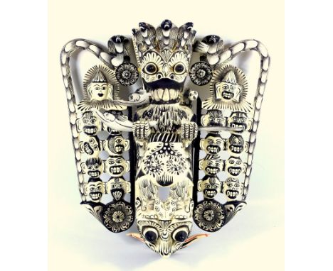 Indonesian Art an intricate carved wood wall hanging, painted black and white, approx 32cm  long. 