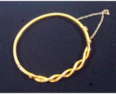 Edwardian hinged gold bangle with twist design, set with small diamond, sapphires and rubies, testing as 15 ct gold. 