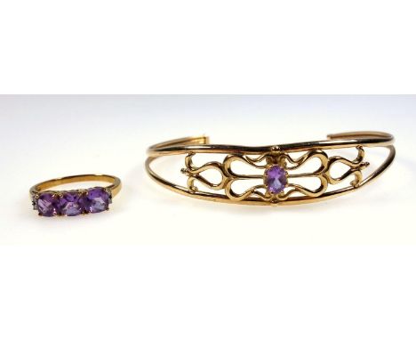 Gold openwork bangle set with an amethyst and a three stone amethyst set ring with diamond set shoulders, both 9ct. (2) 