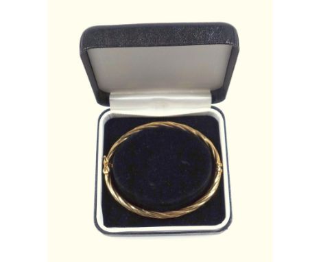 Gold twist design hinged bangle, with safety catch, stamped marks for 9ct gold, interior width 6cm, cased 