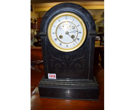 A late Victorian engraved slate mantel clock, 34cm high.  Condition Report: Overall condition of the clock is good.  The glas