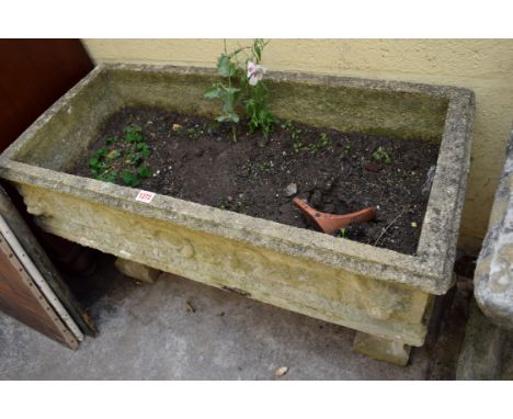 An old weathered composition stone trough style planter, 92cm wide, on end supports. 