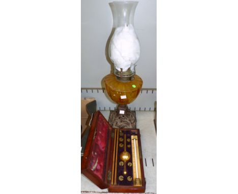 A Sykes Hydrometer in fitted inlaid mahogany box; a 19th century cast iron and amber glass oil lamp and chimney