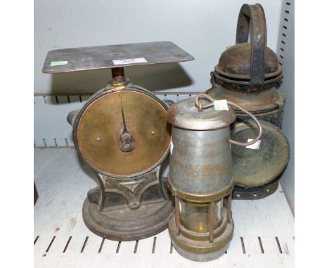 A miner's lamp; an old railway lamp; an old set of parcel scales