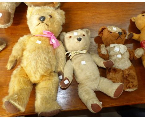 A large 20th century Chiltern teddy with plastic nose and amber eyes, with label, height 20"; a similar white bear, 16"; a si